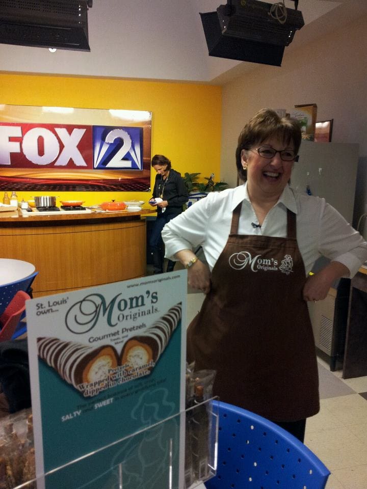 A woman standing in front of a sign.