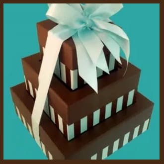 A stack of three chocolate boxes with a bow on top.