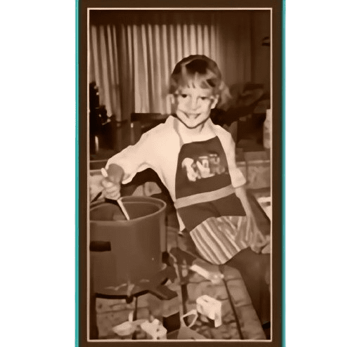 A young girl in an apron is cooking.