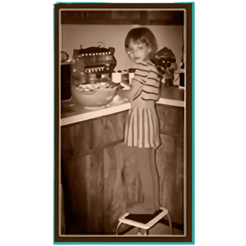 A young girl standing in front of a counter.